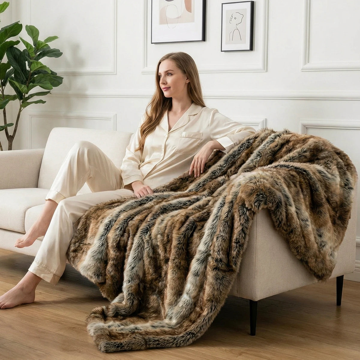 Femme détendue sur un canapé blanc avec le plaid fausse fourrure