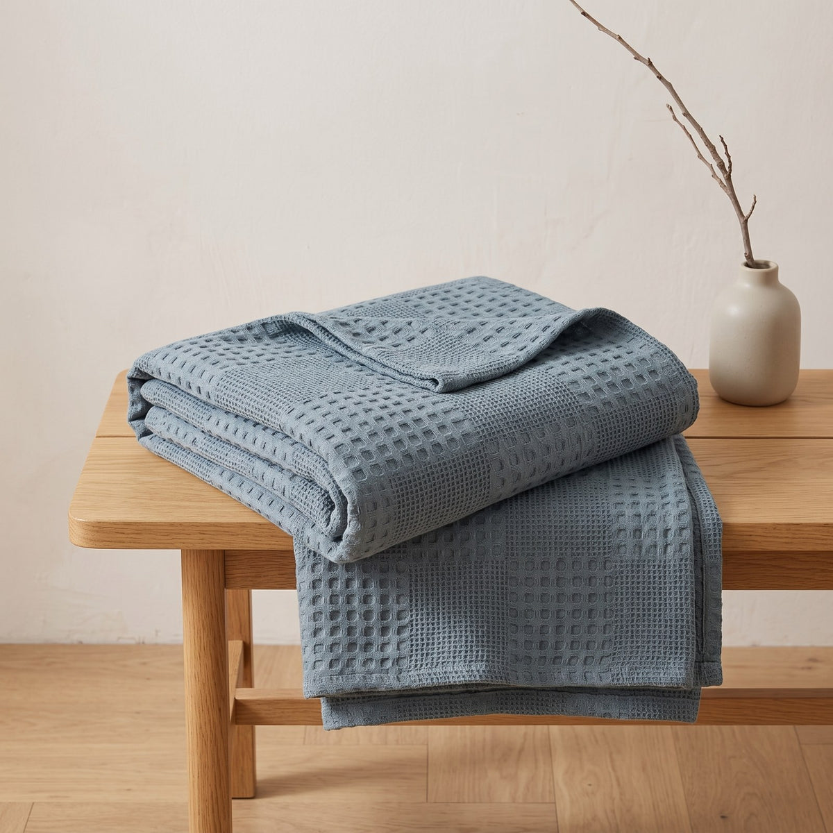 Couleur : Bleu lac - Plaid en coton gaufré bleu lac plié sur un banc en bois